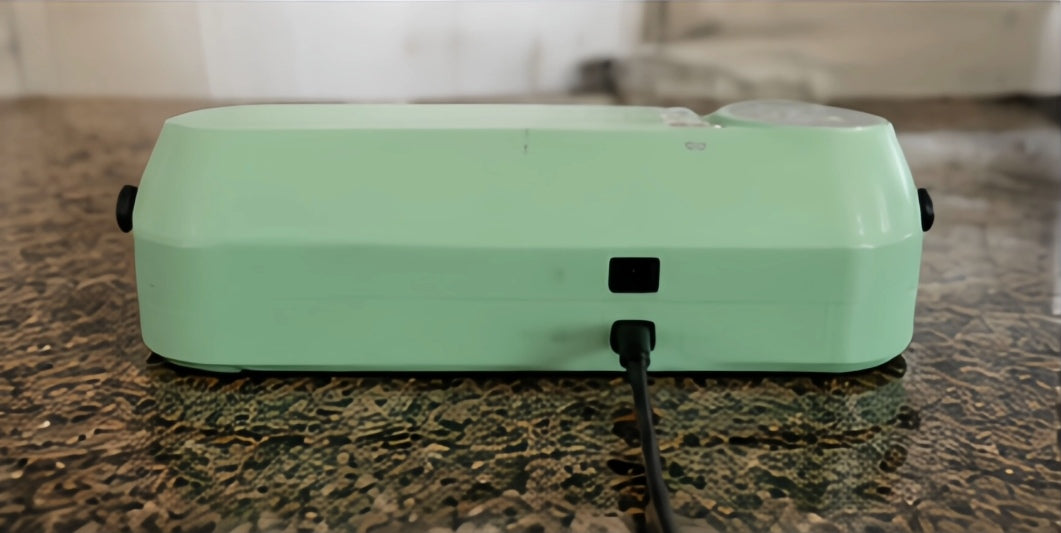Mint green compact vacuum sealer rear view with power connection